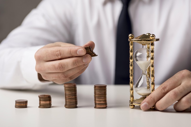 hombre-con-monedas-y-reloj-de-arena-corriendo-el-tiempo-e-inversion