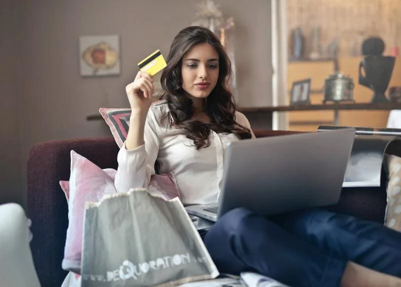 chica-buscando-sitio-web-con-tarjeta-en-mano-para-comprar